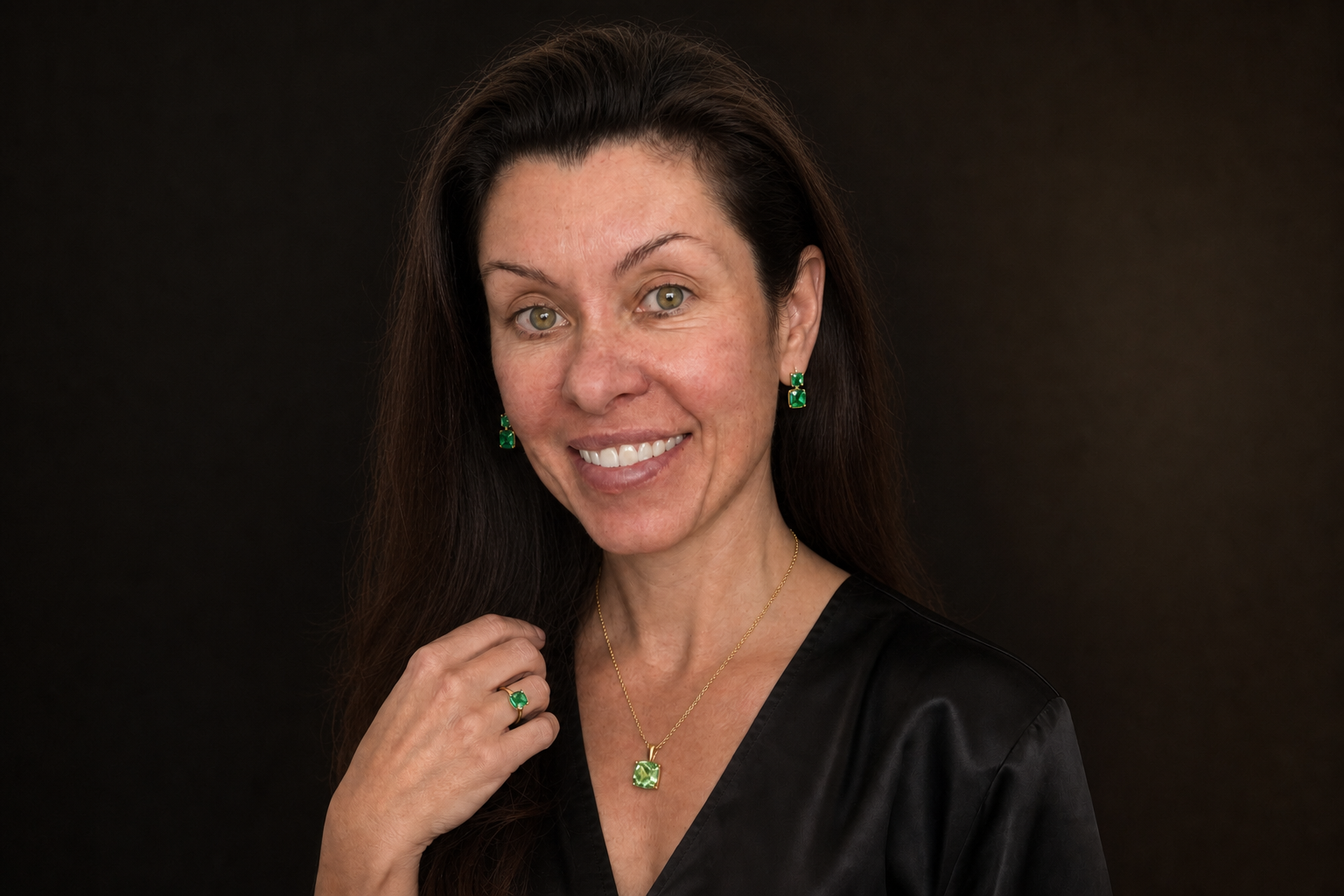 Woman wearing her custom yellow-gold peridot and emerald jewelry set